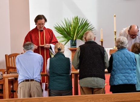 Rev. Peter Rood serves the Eucharist